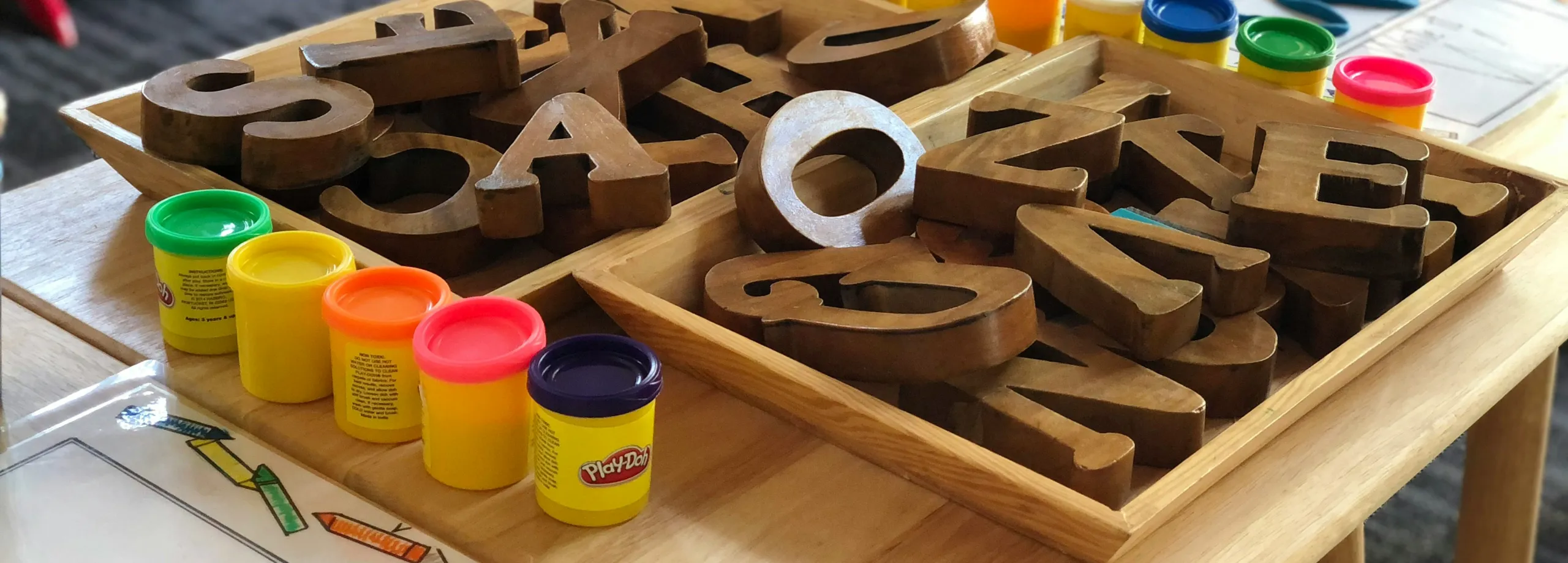 Bokstäver av trä och PlayDoh-burkar